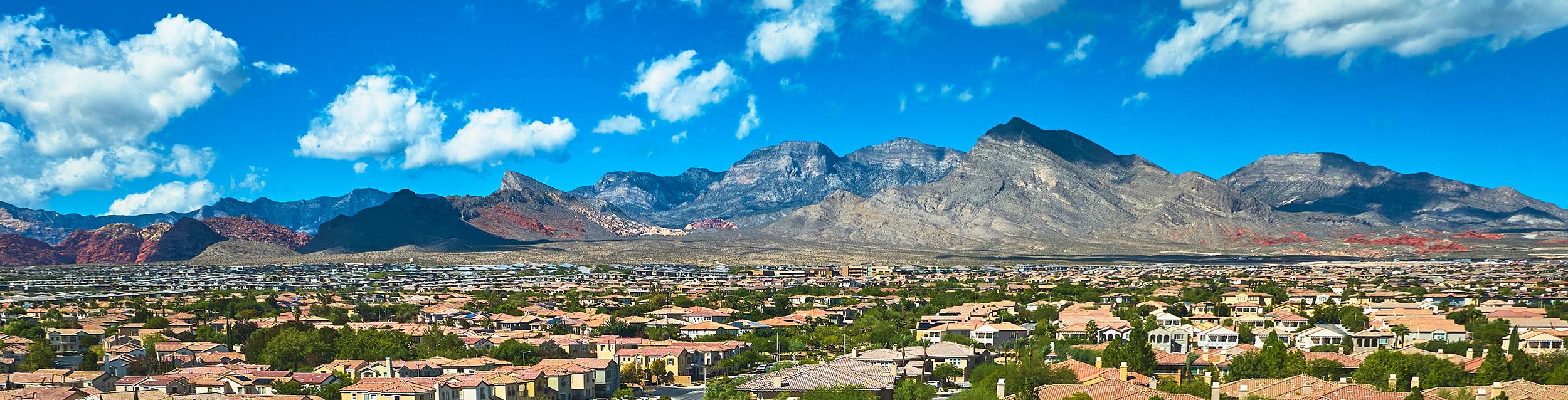 Aerial Las Vegas Residential Neighborhood With Red Rock Mountain And Blue Sky